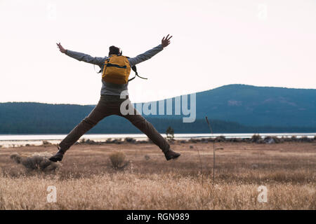 États-unis d'Amérique, Californie, vue arrière du jeune homme saut en randonnée près de Lassen Volcanic National Park Banque D'Images