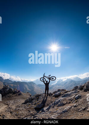 Région frontière Italie Suisse, encourageant l'homme avec mountainbike sur pic de Piz Umbrail Banque D'Images