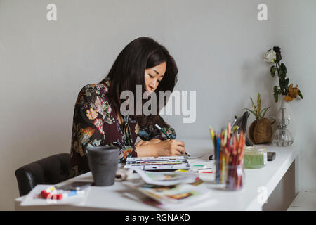 Illustrator dessin à un bureau dans un atelier Banque D'Images