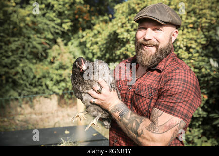 L'homme dans son propre jardin, l'homme avec free range chicken Banque D'Images