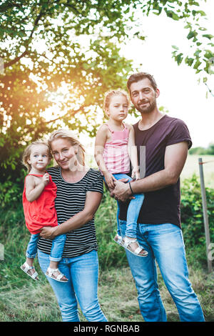Portrait of smiling family avec deux filles debout dans la nature Banque D'Images