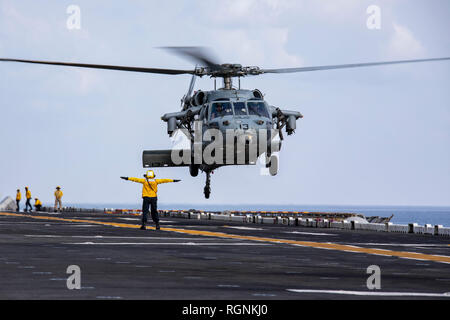 190127-N-WH681-1028 U.S. 5ÈME ZONE DES OPÉRATIONS DE LA FLOTTE (janv. 27, 2019) l'Aviation maître de Manœuvre (manutention) 2e classe Stephanie Vegaortiz dirige un MH-60S Sea Hawk qu'il décolle de l'envol du Wasp-classe d'assaut amphibie USS Kearsarge (DG 3). Kearsarge est le navire amiral de la groupe amphibie Kearsarge et, avec l'entrepris 22e Marine Expeditionary Unit, est déployé sur le 5e flotte américaine zone d'opérations à l'appui des opérations navales pour assurer la stabilité et la sécurité maritime dans la région Centrale, reliant la Méditerranée et le Pacifique à travers l'wester Banque D'Images
