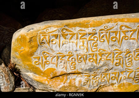 Pierres Mani colorés avec rocher sculpté Mantra bouddhiste de Avalokiteshwara, l'Om Mani Padme Hum Banque D'Images