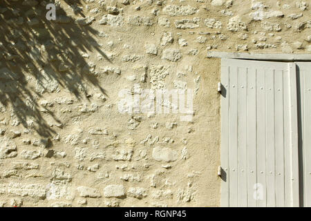 Détail de sunny vieux mur de pierre avec des volets et des ombres, France Banque D'Images