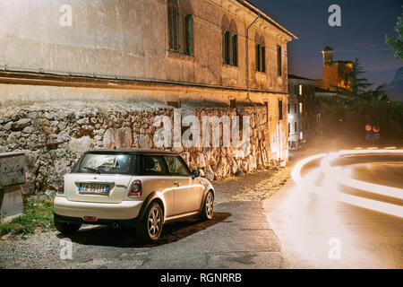 Terracina, Italie - 15 octobre, 2018 Couleur : Blanc pré-berline facelift Mini Cooper R56 Voiture garée sur l'historique Château Castello en Frangipane soir Nig Banque D'Images