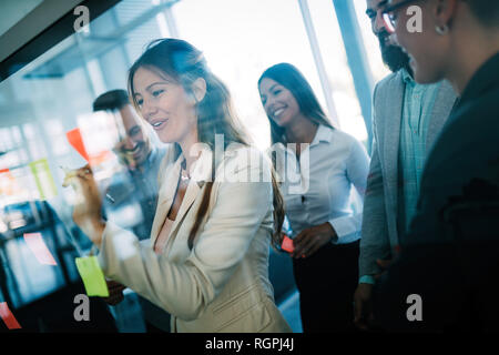 Photo de designers coller notes in office Banque D'Images