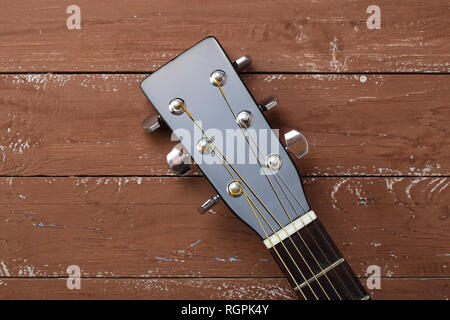 Instrument de musique - Guitare acoustique black peghead de tête sur un fond de bois. Banque D'Images