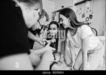 L'équipe de photographes montrant des images à l'écran de l'appareil photo pour des jumeaux modèles filles sur studio. Photographe professionnel sur le travail. Banque D'Images