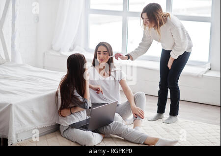 Artiste de préparer deux jumeaux modèles avec ordinateur portable en studio avant séance photo. Banque D'Images