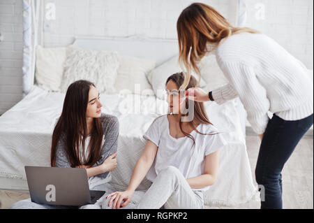 Artiste de préparer deux jumeaux modèles avec ordinateur portable en studio avant séance photo. Banque D'Images