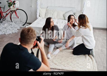 Artiste de préparer deux jumeaux modèles avec ordinateur portable en studio avant séance photo. Photographe prise de vue. Le travail d'équipe ensemble. Banque D'Images