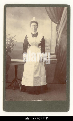 Edwardian Carte de Visite portrait de femme portant un tablier à bavette dentelle Dentelle et cap, vers 1903, au Royaume-Uni. Banque D'Images