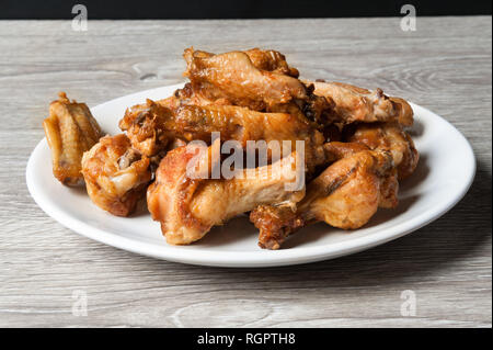 Fried Chiken wings dans la plaque blanche sur fond de bois Banque D'Images