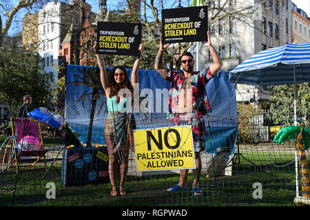 Deux modèles se tiennent sur un 'Beach' de barbelés à l'extérieur des bureaux de TripAdvisor à Soho Square, centre de Londres, dans le cadre d'une campagne d'Amnesty International demande à l'entreprise et d'autres compagnies de voyage pour arrêter l'inscription chambres et activités dans les colonies de peuplement israéliennes dans les territoires palestiniens. Banque D'Images