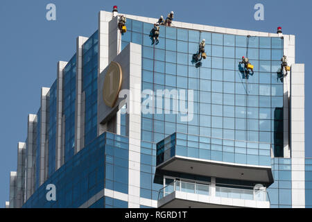 Dubaï, Émirats arabes unis - 15 Février 2018 : Les hommes de nettoyer la façade de la gratte-ciel moderne à Dubaï, Émirats Arabes Unis Banque D'Images