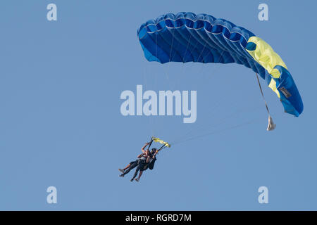 Dubaï, Émirats arabes unis - 16 Février 2018 : Tandem skydivers effectuant le parachutisme avec des parachutes et bleu ciel ouvert À DUBAÏ, ÉMIRATS ARABES UNIS Banque D'Images