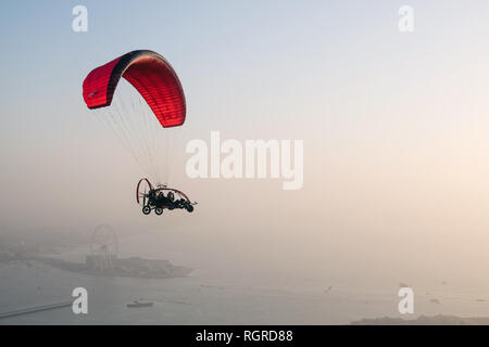 Dubaï, Émirats arabes unis - 16 Février 2018 : vol biplace paramoteur SkyHub à partir de la Marina de Dubaï au-dessus de Palm Jumeirah à Dubai, UAE au crépuscule Banque D'Images