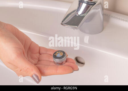 Réparation de la grue aérateur. Purification de l'aérateur de dépôts. La main de la jeune fille tient en mains un vieux calcaire sale de l'aérateur mixe Banque D'Images