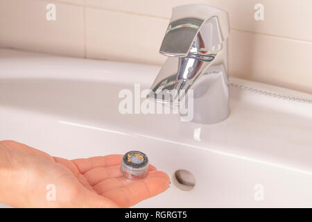 Réparation de la grue aérateur. Purification de l'aérateur de dépôts. La main de la jeune fille tient en mains un vieux calcaire sale de l'aérateur mixe Banque D'Images
