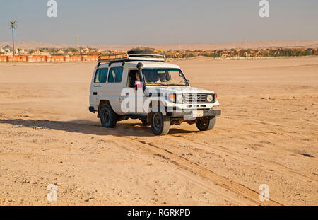 Hurghada, Egypte- Février 26, 2017 : voiture off road drive sur paysage désertique. Pour safari en jeep sur ciel bleu ensoleillé. Voyages en automobile camion dans la dune de sable. Wanderlust et l'aventure. Défi, la vitesse et l'extrême concept. Banque D'Images