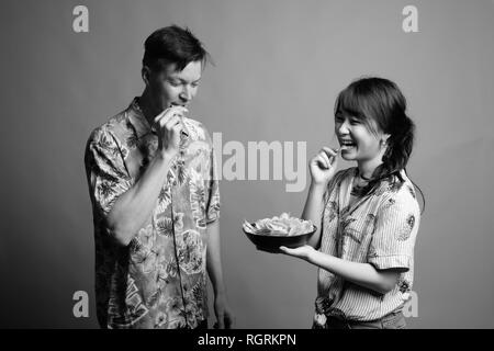 Couple de touristes ethniques multiples ayant des croustilles comme snack Banque D'Images