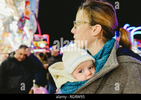 Transport bébé dans une écharpe kangourou par sa mère. Banque D'Images