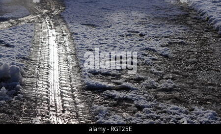 La bande de roulement des pneus marque imprimée dans la neige sur une route glacée en hiver. Banque D'Images