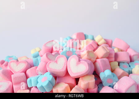 Paire de boutons en forme de coeur rose et blanc de la guimauve sur le tas de guimauve en forme de fleur de couleur pastel Candies avec de l'espace libre pour le texte et la conception Banque D'Images