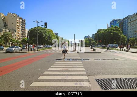 Femme marche sur le Carrefour de l'avenue 9 de Julio avec l'obélisque de Buenos Aires dans la Distance, Buenos Aires, Argentine Banque D'Images