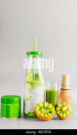 Matcha latte en couches vegan sain boire en bouteille avec paille debout sur table à fond gris clair. Matcha espresso. L'alimentation, de Banque D'Images