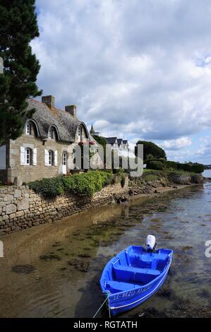 Petit bateau bleu en face d'une maison en pierre à Saint Cado Morbihan Bretagne France Banque D'Images