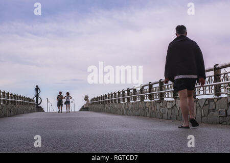 TONFANO, Lucca, ITALIE - 13 août 2018 : trois inconnus à pied sur la jetée Tonfano, un travail de l'architecte Tiziano Lera construit en 2008, une station Banque D'Images