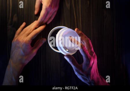 Un couple d'amoureux à la table. Vue d'en haut. Mains en papier en plastique table en bois belle lumière Banque D'Images