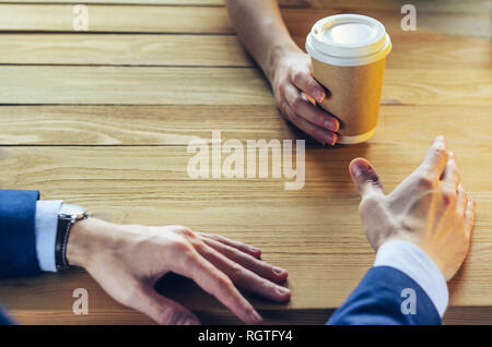 Barista sert du café à un homme. Coupe papier en plastique table en bois Pause Blazer. Pause café Concept Banque D'Images