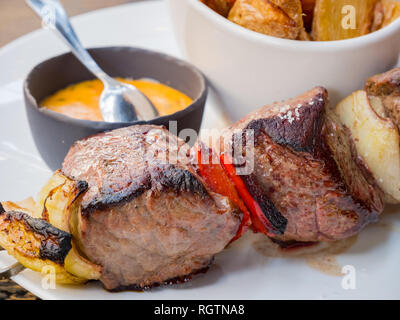 Gros plan de brochettes de boeuf et frites, mangé à Paris, France Banque D'Images