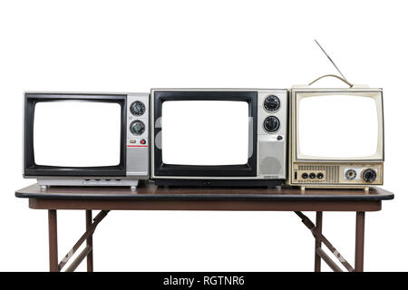 Trois téléviseurs vintage sur table en bois isolé sur blanc avec cut out écrans. Banque D'Images