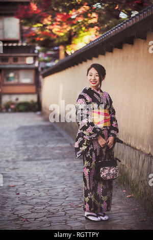 KANAZAWA, JAPON - le 28 novembre : japonaise en kimono posant dans Nagamachi samurai district. La région conserve des résidences de samouraïs, murs en terre, ent Banque D'Images