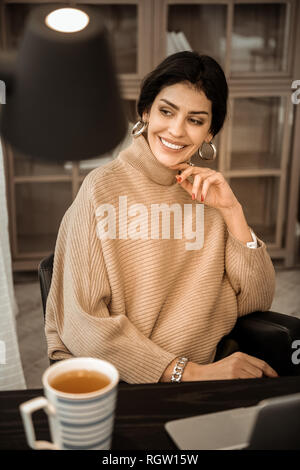 Bon à la dame brune avec des boucles d'or et grand sourire Banque D'Images