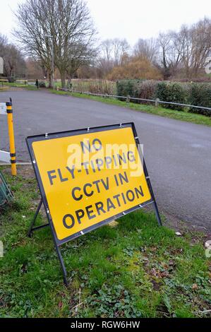 Un panneau routier avertissement sur 'No Fly Tipping CCTV dans opération' sur une paisible route de campagne England UK Surrey Shepperton Banque D'Images
