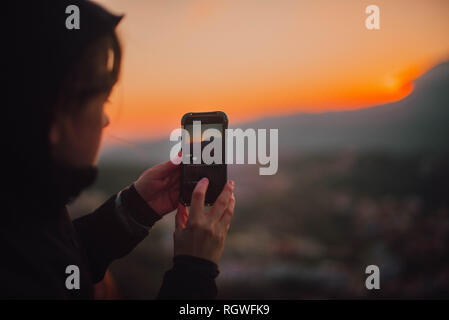 Coucher de soleil sur smartphone tir Femme Banque D'Images