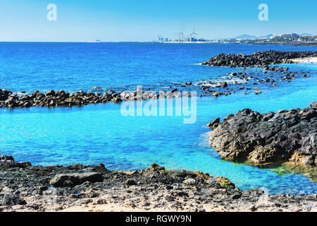 Lagon aux eaux turquoise de l'eau claire en Playa Jablillo, plage de Costa Teguise, Lanzarote, îles Canaries. Plage de sable fin avec la mer bleue, les roches volcaniques Banque D'Images