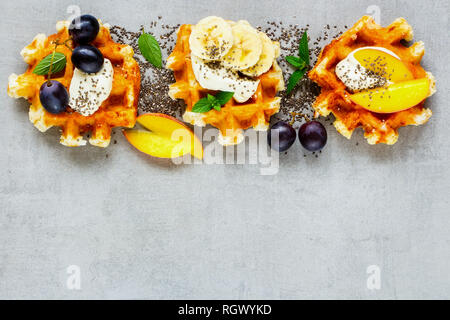 Gaufres Belges, divers fruits et crème fouettée close up. Mise à plat Banque D'Images