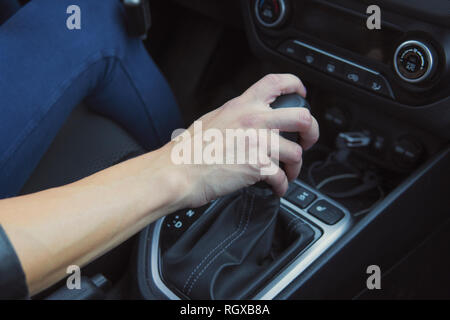 Close up of woman du passage des vitesses sur la transmission automatique et la conduite automobile. Les changements de main de femme assise hydro dans un véhicule. Affaires Auto, location vente, con Banque D'Images