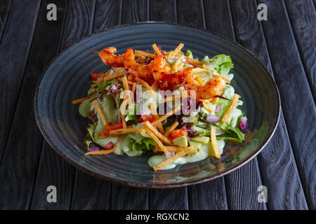 Crevettes sur broche avec salade, avocat, tomate et chips de pita Banque D'Images