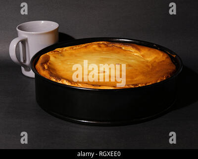 Gâteau au fromage frais cuit dans un ruisseau, forme, avec une tasse de café. Banque D'Images