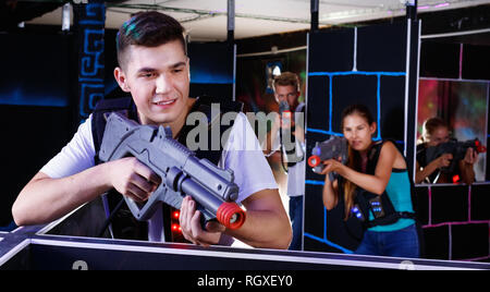 Portrait of smiling guy positive heureux excité avec pistolet laser laser tag arena en jouant Banque D'Images