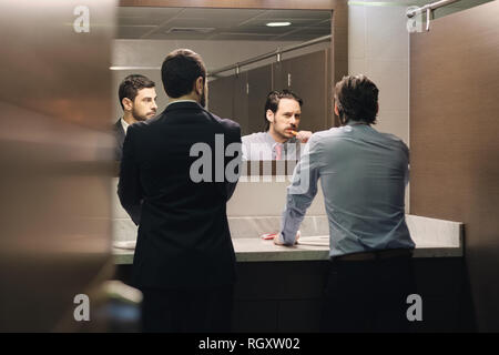 L'homme d'affaires se brosser les dents après le déjeuner en salle de bains Bureau Banque D'Images