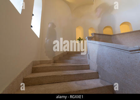 Femme Ghost Walking Down Staircase avec windows en Italie. Banque D'Images