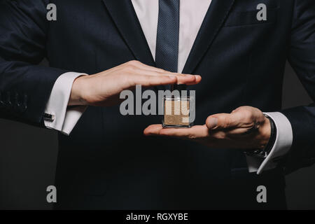 Portrait de l'homme tenue à Cologne le flacon en verre isolé sur black Banque D'Images