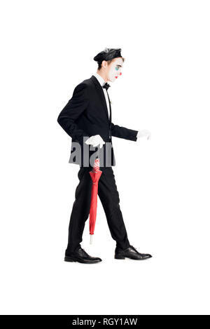 En clown costume et béret noir holding umbrella en marchant isolated on white Banque D'Images